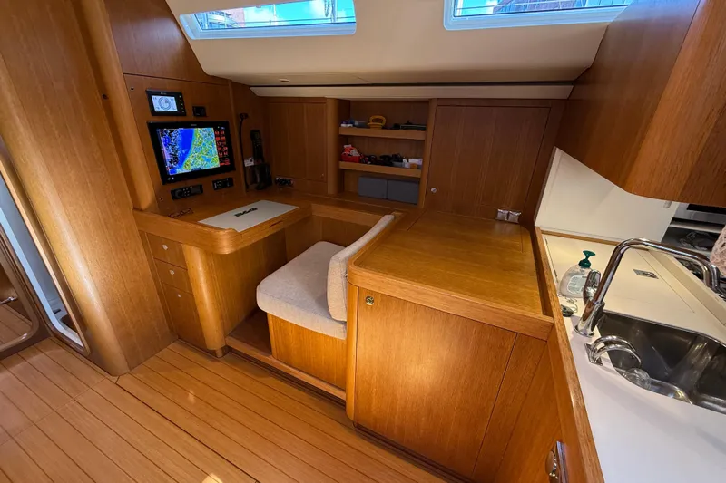 Pau Hana Yacht Photos Pics Luxurious interior of 2019 Nautor Swan 54 yacht with navigation station and wooden cabinetry.