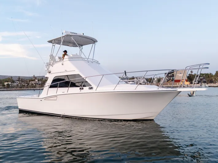 More Good Yacht Photos Pics 2002 Cabo 35 Flybridge boat on calm water, clear sky background.