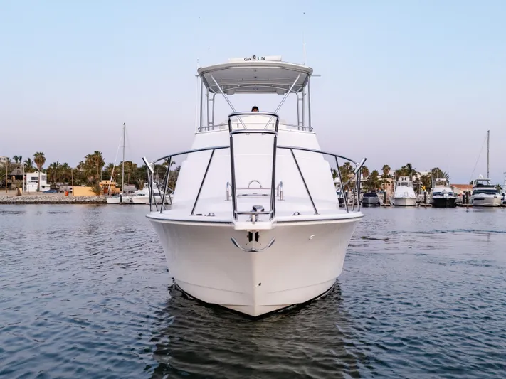 More Good Yacht Photos Pics 2002 Cabo 35 Flybridge yacht on calm water, marina background.
