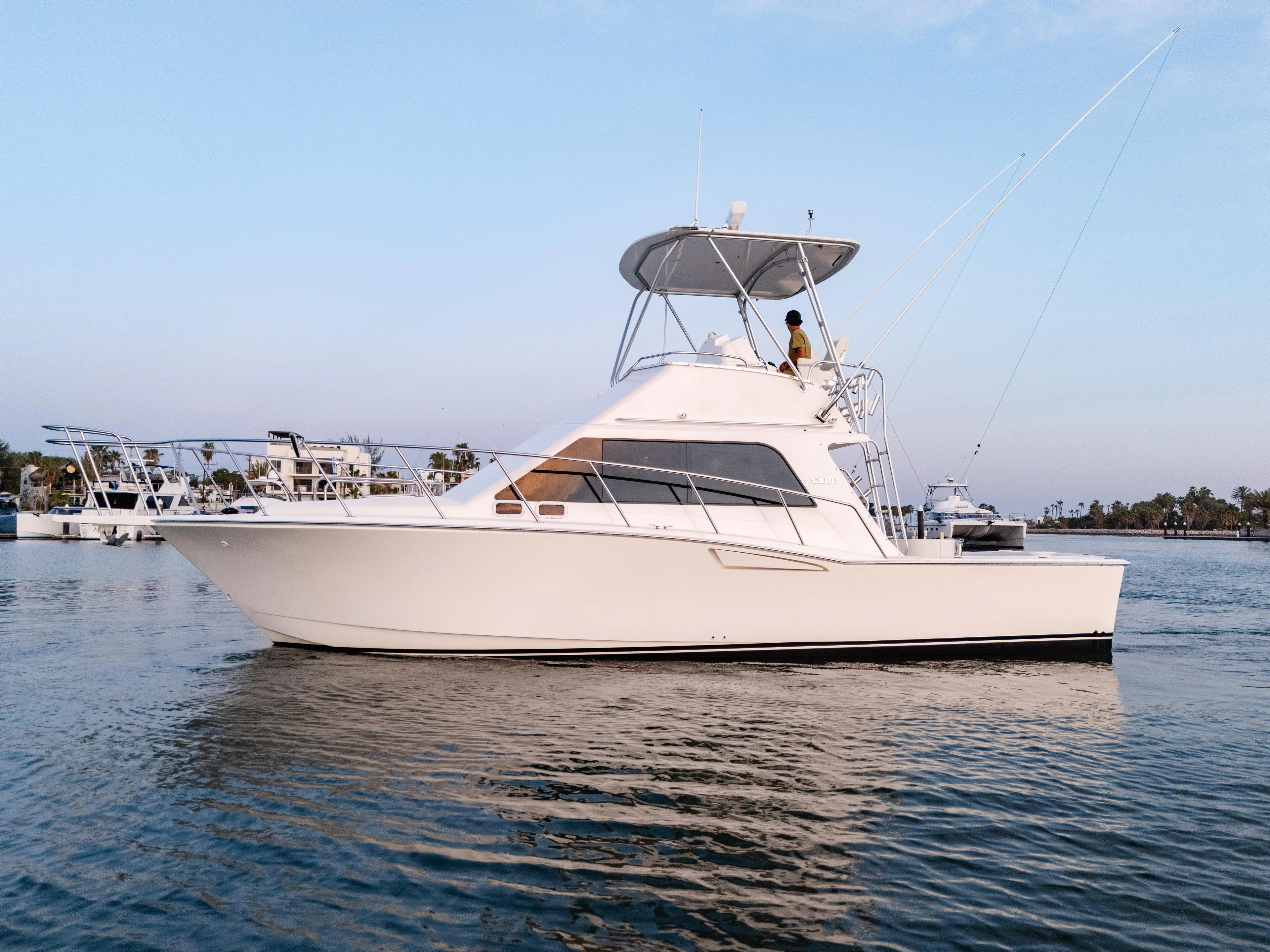 More Good Yacht Photos Pics 2002 Cabo 35 Flybridge yacht on calm water, side view, clear sky background.