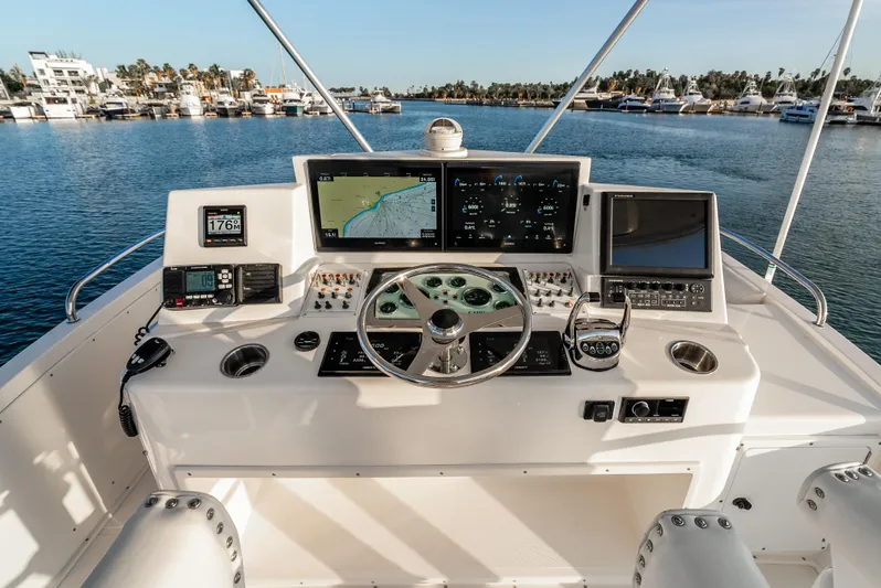 More Good Yacht Photos Pics Flybridge helm of 2002 Cabo 35, featuring navigation screens and controls, overlooking marina.