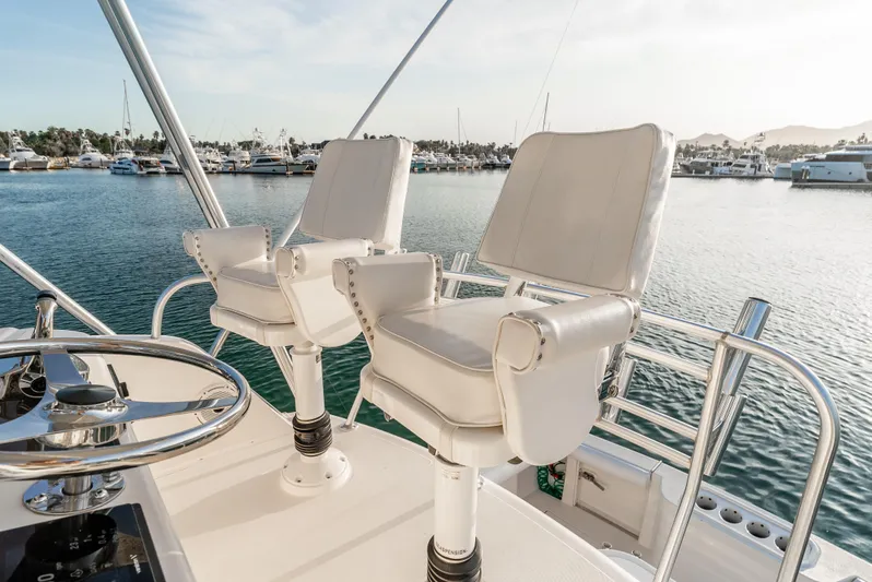 More Good Yacht Photos Pics Flybridge of 2002 Cabo 35, featuring white captain chairs and marina view.