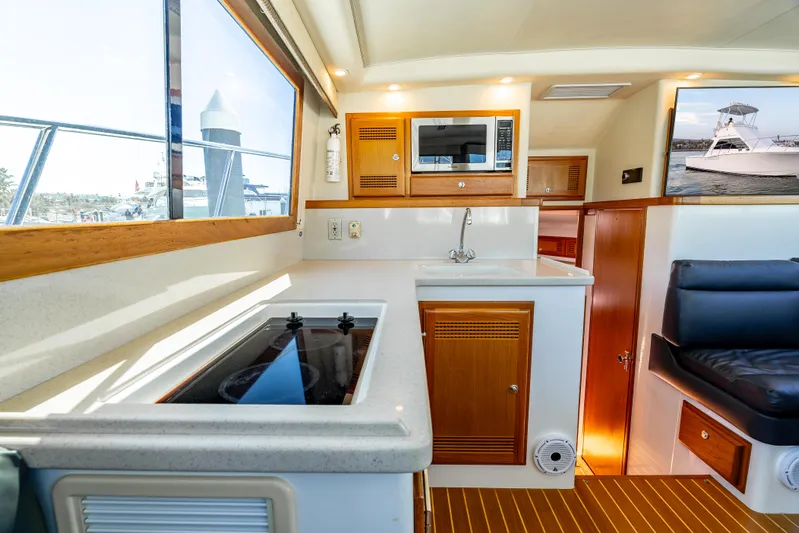 More Good Yacht Photos Pics Interior of 2002 Cabo 35 Flybridge yacht with kitchenette and seating area.