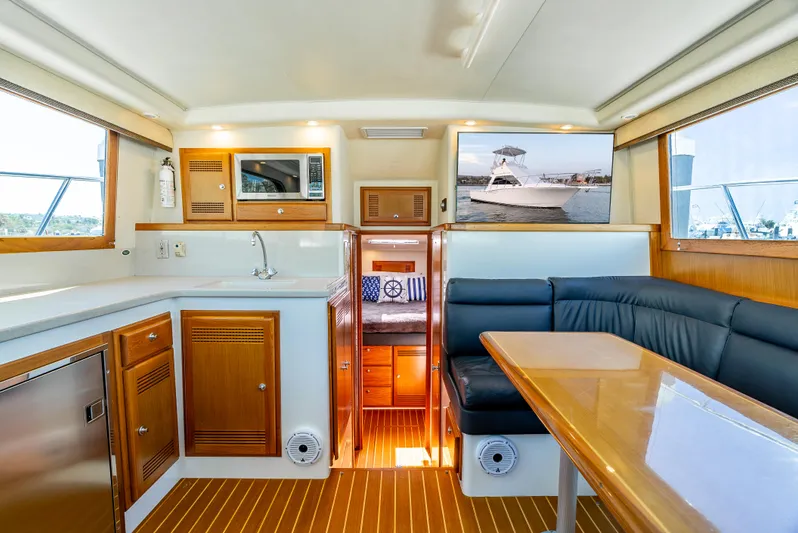 More Good Yacht Photos Pics Interior of 2002 Cabo 35 Flybridge yacht with kitchen, seating, and wood accents.