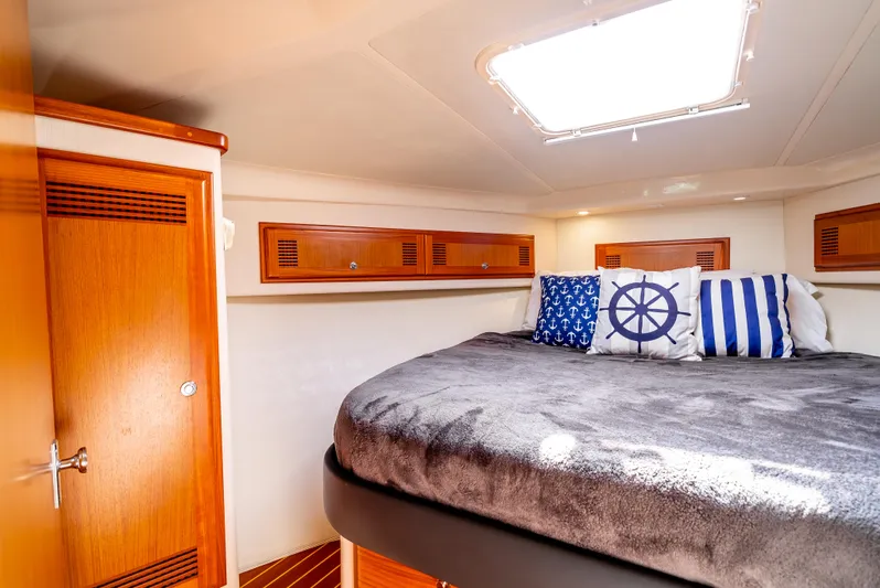 More Good Yacht Photos Pics Cozy cabin interior of 2002 Cabo 35 Flybridge with nautical-themed pillows and wooden accents.