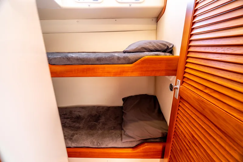 More Good Yacht Photos Pics Bunk beds in 2002 Cabo 35 Flybridge cabin with wooden accents and cozy bedding.