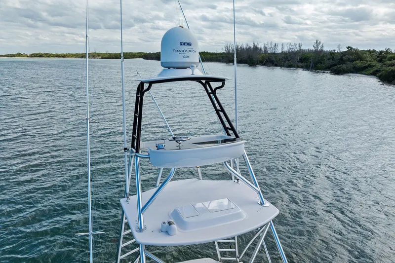 Knot Haulin Yacht Photos Pics 2017 Spencer Convertible boat with radar tower on calm water, surrounded by lush greenery.