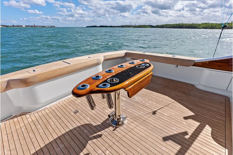 Knot Haulin Yacht Photos Pics 2017 Spencer Convertible yacht deck with rod holders, overlooking serene ocean waters.