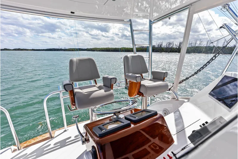 Knot Haulin Yacht Photos Pics Luxury helm of 2017 Spencer Convertible yacht with dual captain chairs on open water.