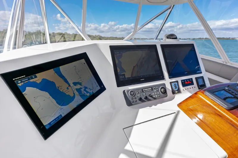 Knot Haulin Yacht Photos Pics 2017 Spencer Convertible yacht dashboard with navigation screens and controls, overlooking serene waters.