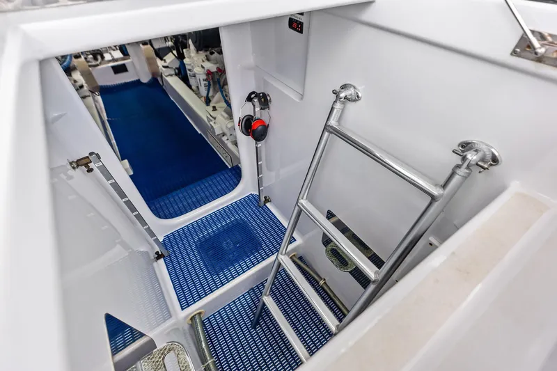 Knot Haulin Yacht Photos Pics Engine room access with ladder in 2017 Spencer Convertible boat, featuring blue flooring.