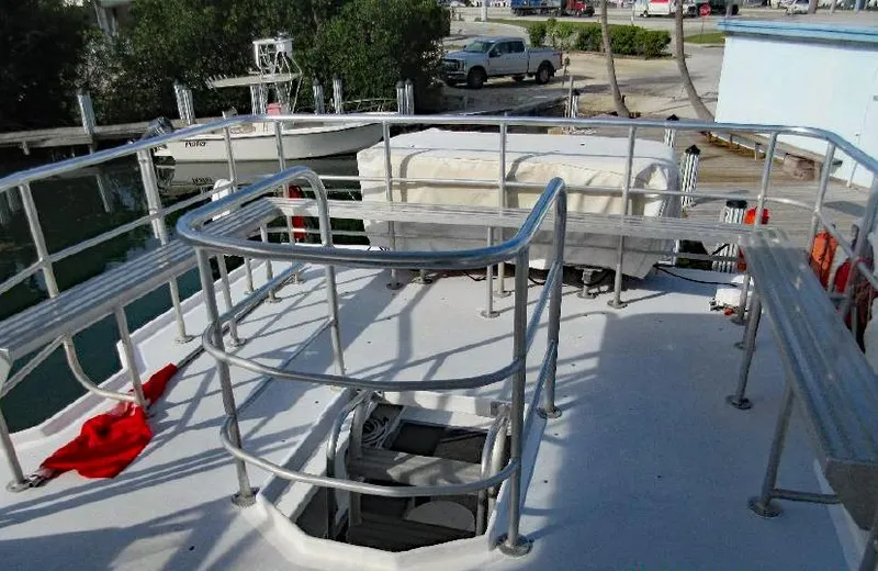  Yacht Photos Pics 2004 Newton 46 Dive Special boat deck with railing and hatch, docked near water.