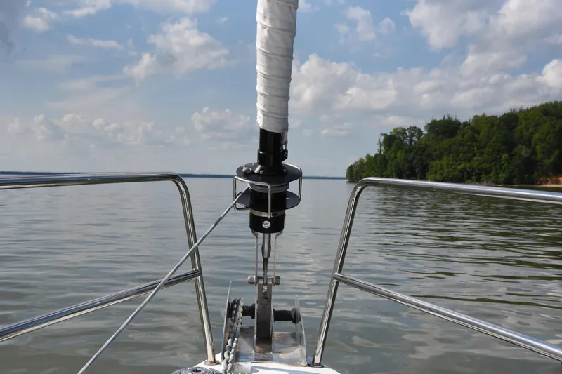 Recovery Room Yacht Photos Pics Bow view of a 2019 Jeanneau 51 sailboat on calm waters under a cloudy sky.
