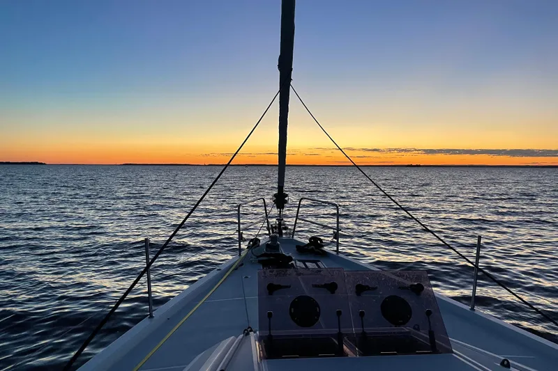 Recovery Room Yacht Photos Pics Sailing on a 2019 Jeanneau 51 yacht at sunset over calm waters.