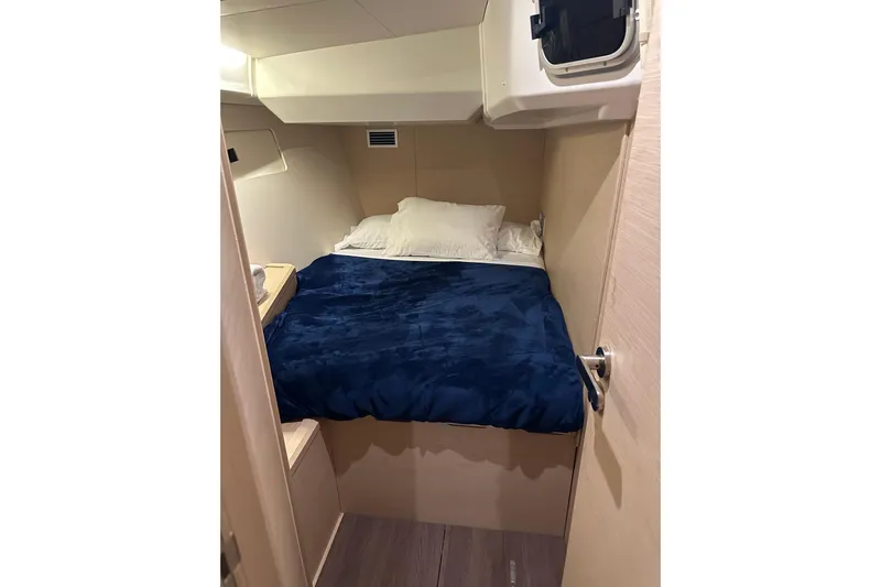 Recovery Room Yacht Photos Pics Cozy cabin interior of 2019 Jeanneau 51 yacht with blue bedding.