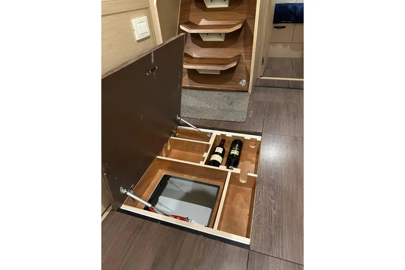 Recovery Room Yacht Photos Pics Hidden wine storage in 2019 Jeanneau 51 yacht interior, featuring wooden compartments.