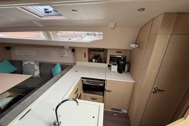 Recovery Room Yacht Photos Pics Modern interior of 2019 Jeanneau 51 yacht with kitchen and seating area.