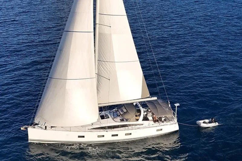 Miss Fiona Yacht Photos Pics 2020 Jeanneau 64 yacht sailing on open sea with dinghy in tow.