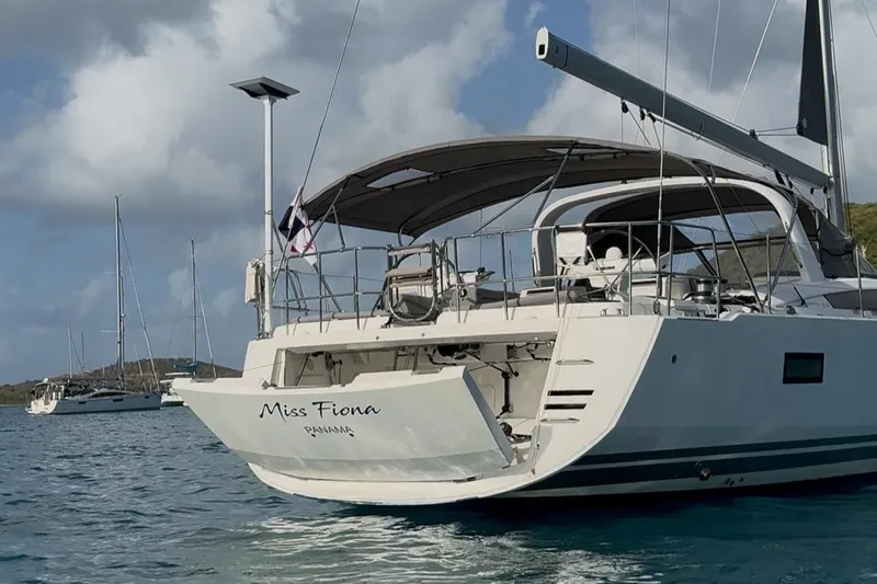 Miss Fiona Yacht Photos Pics 2020 Jeanneau 64 yacht "Miss Fiona" anchored in calm waters under a cloudy sky.