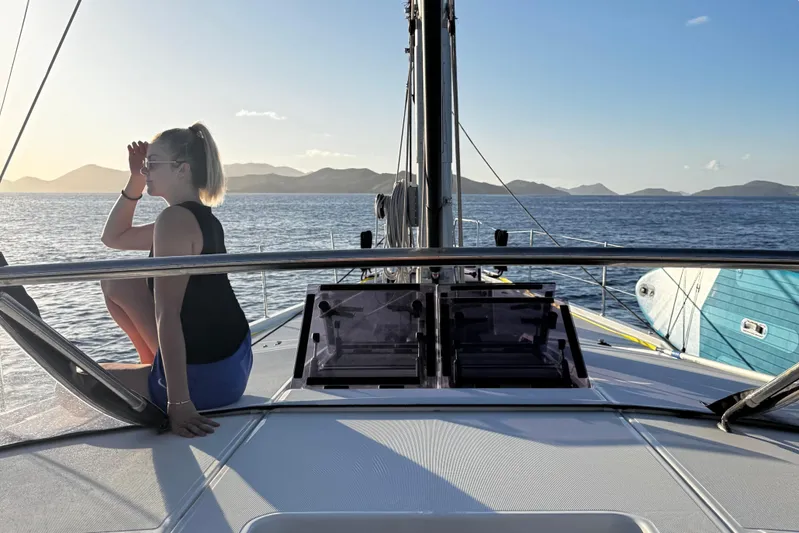 Miss Fiona Yacht Photos Pics Woman enjoying sunset on Jeanneau 64 yacht, 2020 model, with scenic ocean view.