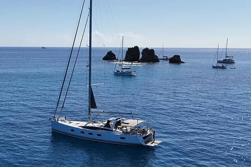 Miss Fiona Yacht Photos Pics 2020 Jeanneau 64 yacht sailing near rocky islets in clear blue waters.