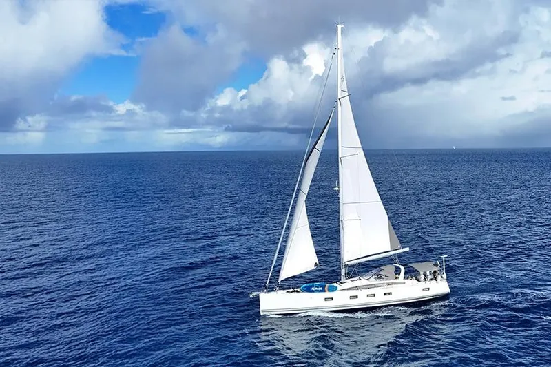 Miss Fiona Yacht Photos Pics 2020 Jeanneau 64 sailing yacht on open ocean under cloudy sky.