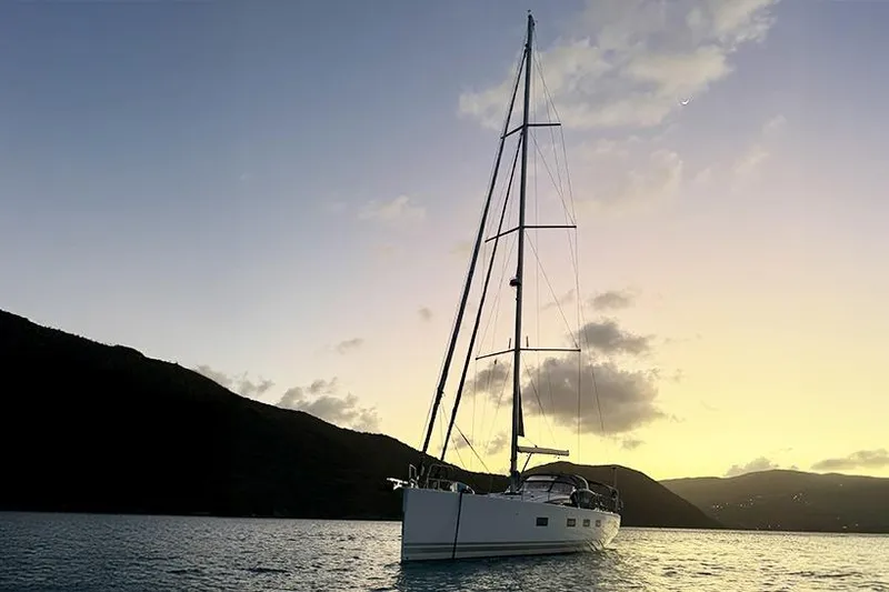 Miss Fiona Yacht Photos Pics 2020 Jeanneau 64 yacht at sunset, anchored in tranquil waters.
