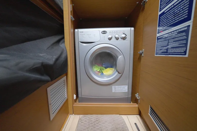 Miss Fiona Yacht Photos Pics Washing machine inside Jeanneau 64 yacht, 2020 model, in wooden cabinet.