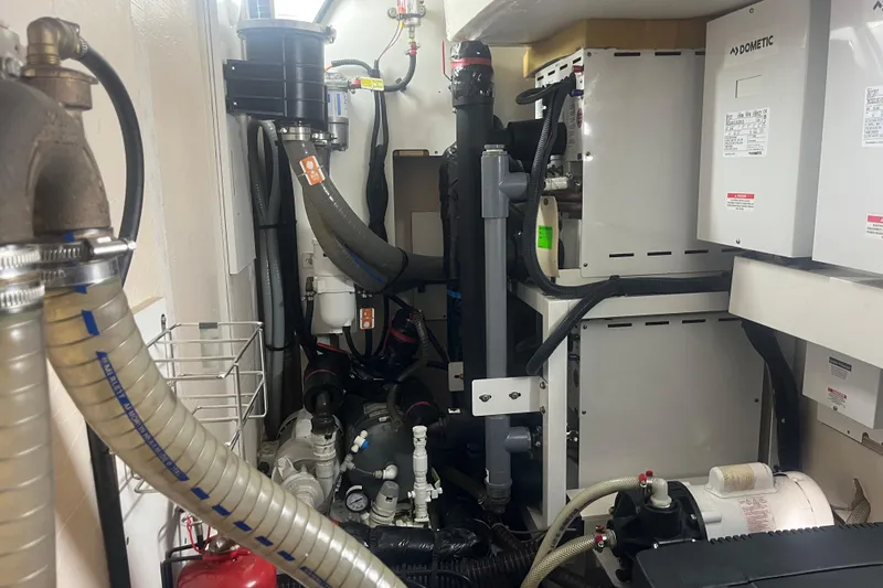 Miss Fiona Yacht Photos Pics Engine room of a 2020 Jeanneau 64 yacht with mechanical equipment and piping.