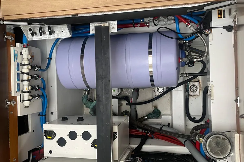 Miss Fiona Yacht Photos Pics Engine room of a 2020 Jeanneau 64 yacht, featuring plumbing and mechanical components.