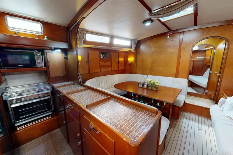 Yacht Photos Pics Interior of 1991 Amel Super Maramu yacht with kitchen and dining area.