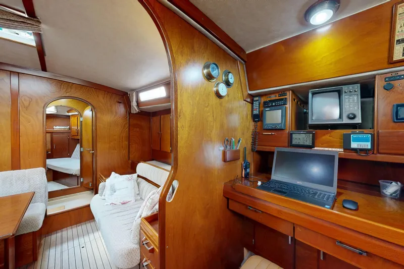  Yacht Photos Pics Interior of 1991 Amel Super Maramu yacht with wooden furnishings and navigation equipment.