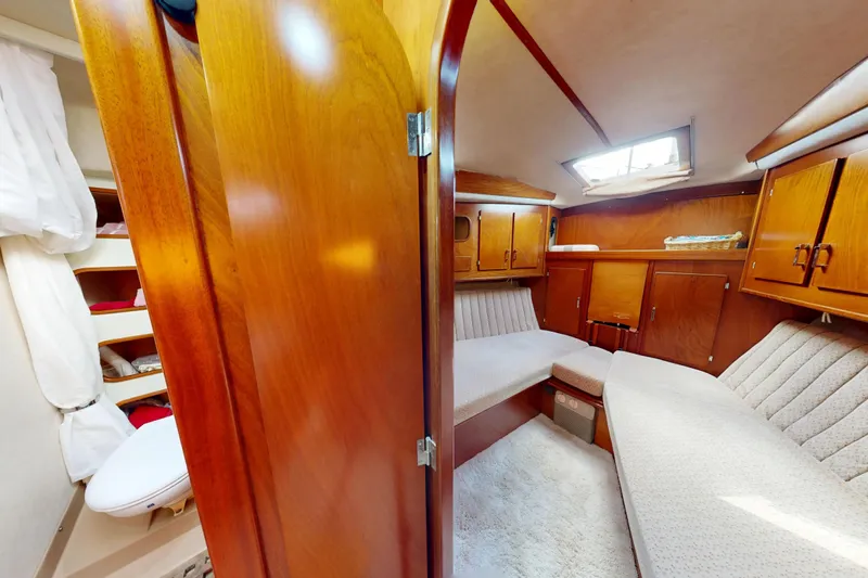 Yacht Photos Pics Interior of 1991 Amel Super Maramu yacht with cozy seating and wooden cabinetry.