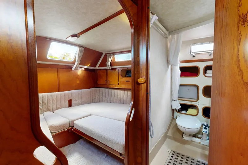  Yacht Photos Pics Cozy cabin interior of 1991 Amel Super Maramu sailboat with wood finish and compact bathroom.