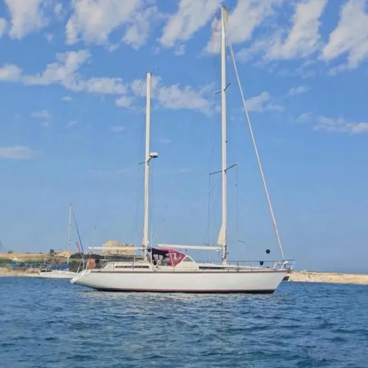  Yacht Photos Pics Sailing yacht Amel Super Maramu 1991 on calm sea with clear blue sky.