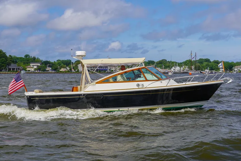 Meandher Yacht Photos Pics 2009 Hunt Yachts Harrier 29 cruising on a scenic waterway with American flag.