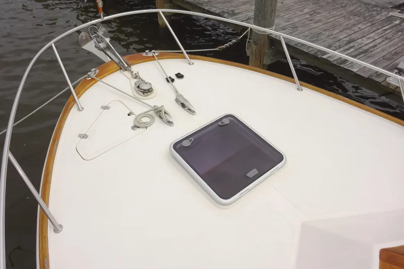 Meandher Yacht Photos Pics 2009 Hunt Yachts Harrier 29 bow with hatch and railing, docked by wooden pier.