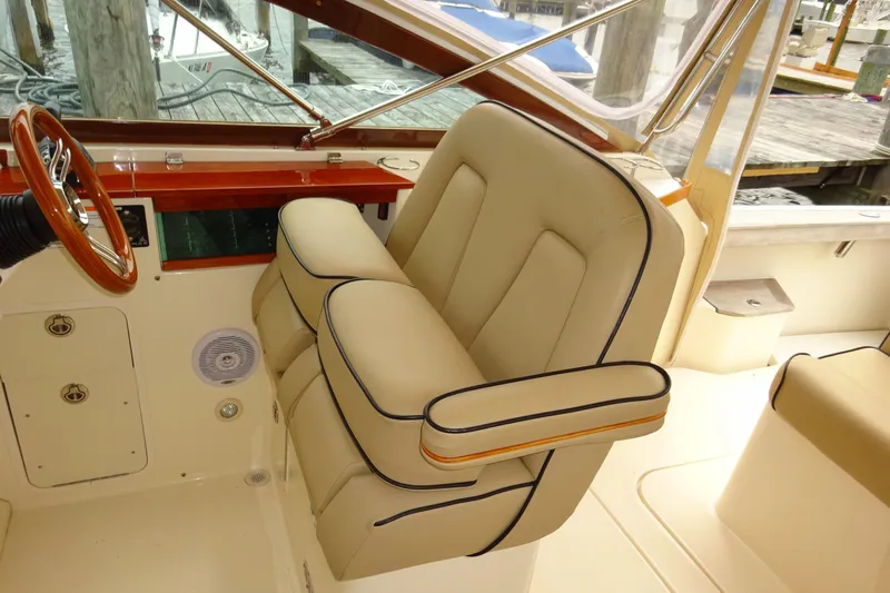Meandher Yacht Photos Pics 2009 Hunt Yachts Harrier 29 interior with beige seating and wooden steering wheel.