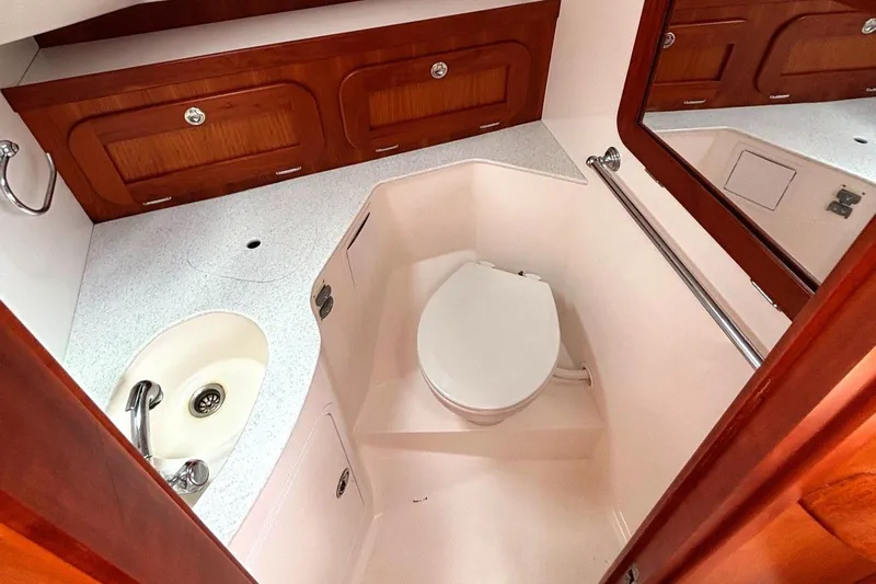 Meandher Yacht Photos Pics 2009 Hunt Yachts Harrier 29 bathroom with sink, toilet, and wooden cabinetry.