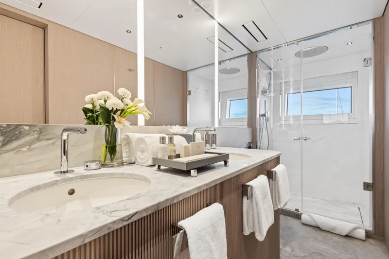 Contigo Yacht Photos Pics Luxurious bathroom on 2024 Benetti Oasis 40M yacht with marble countertop and glass shower.