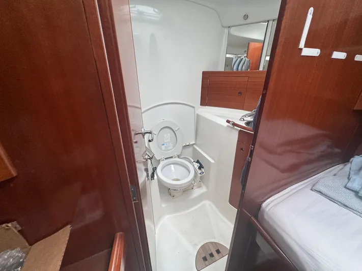 Kaleidoscope Yacht Photos Pics Beneteau First 47.7 yacht bathroom interior, 2004 model, featuring wooden cabinetry and compact design.