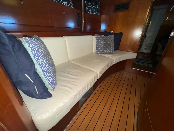 Kaleidoscope Yacht Photos Pics Luxurious interior of 2004 Beneteau First 47.7 yacht with cushioned seating and wooden flooring.