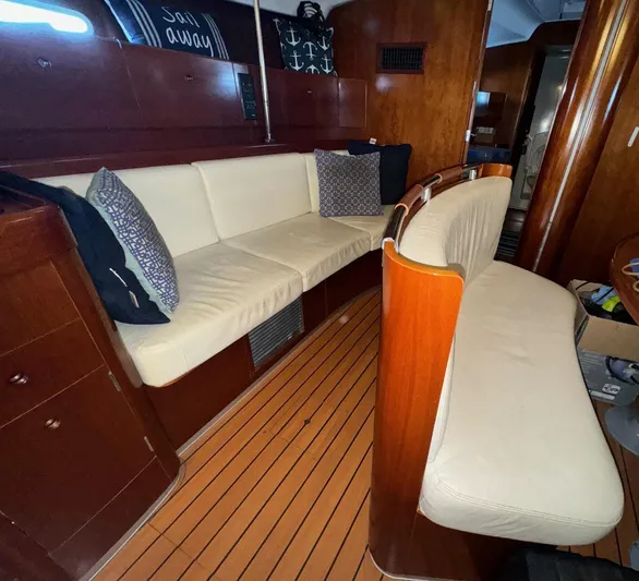 Kaleidoscope Yacht Photos Pics Interior of 2004 Beneteau First 47.7 yacht with wooden finish and cushioned seating.