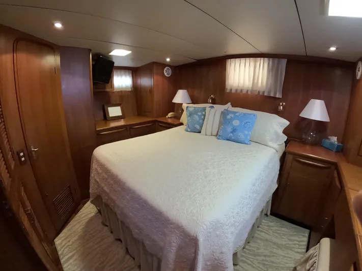 Intoxication Yacht Photos Pics Luxurious bedroom interior of 1995 Jefferson 48 Rivanna yacht with cozy bedding and wooden furnishings.