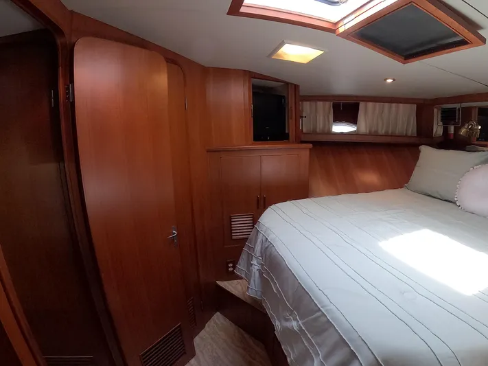 Intoxication Yacht Photos Pics Cozy bedroom interior of 1995 Jefferson 48 Rivanna yacht with wooden cabinetry and skylight.