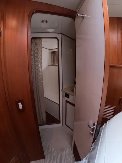Intoxication Yacht Photos Pics Interior of 1995 Jefferson 48 Rivanna yacht, featuring a wooden door and compact bathroom.