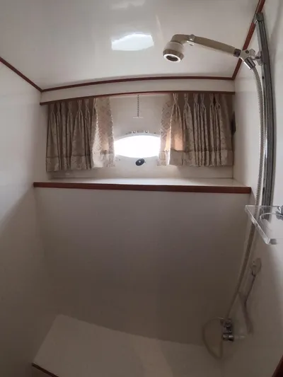 Intoxication Yacht Photos Pics Shower area in a 1995 Jefferson 48 Rivanna yacht with curtains and window.