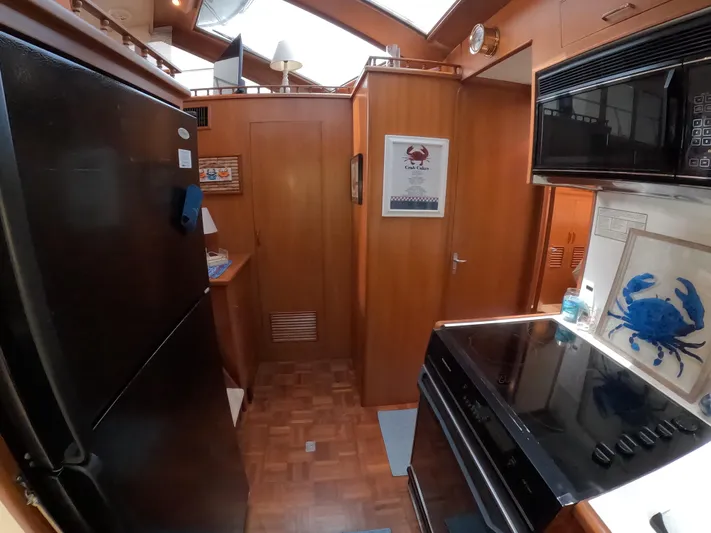 Intoxication Yacht Photos Pics Interior of 1995 Jefferson 48 Rivanna yacht kitchen with wood cabinetry and modern appliances.
