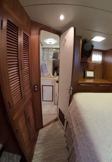 Intoxication Yacht Photos Pics Interior of 1995 Jefferson 48 Rivanna yacht, featuring wood paneling and cozy bedroom.