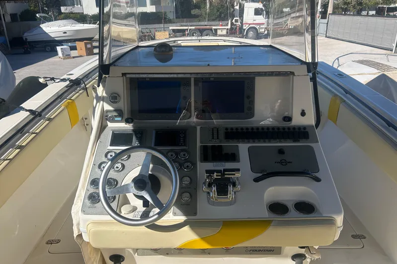 4play Yacht Photos Pics 2013 Fountain 38 Sportfish CC Open Bow helm with steering wheel and control panel.